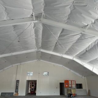 Fiberglass batt insulation installed in the ceiling of a metal building.