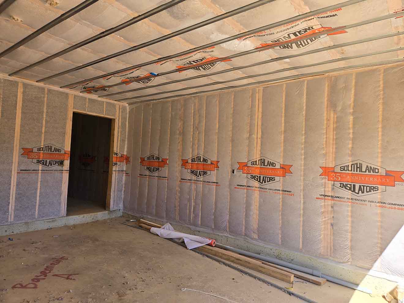 Fiberglass batt insulation installed in garage ceiling and wall framing by Southland Insulators in Virginia.