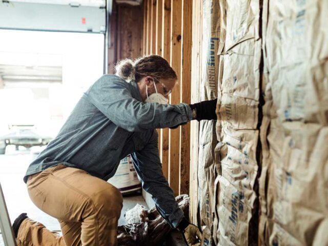 A detailed image displays a section of Knauf fiberglass insulation, showcasing its fluffy texture, emphasizing its effectiveness in soundproofing and energy efficiency for homes and buildings.