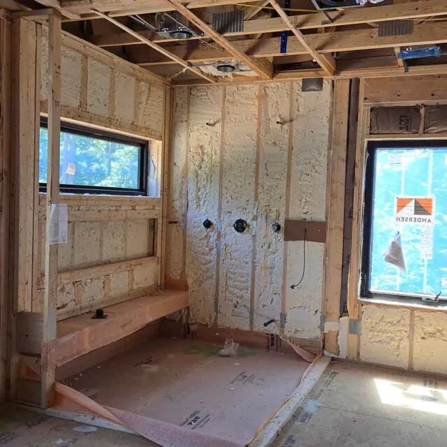 Open-cell spray foam insulation applied to exterior wall cavities in a new construction.