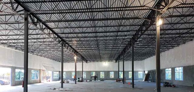Vinyl-faced fiberglass insulation installed along upper walls of tilt-up commercial building.