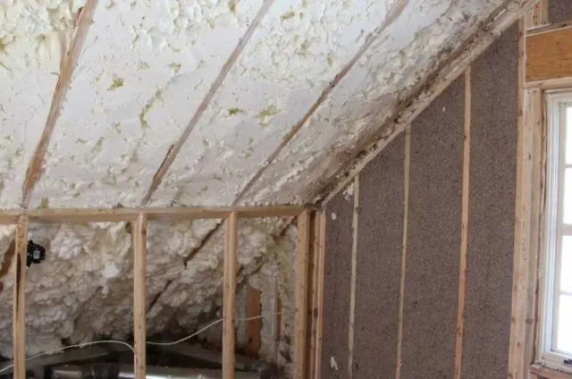 Hybrid open cell spray foam and cellulose in an attic.
