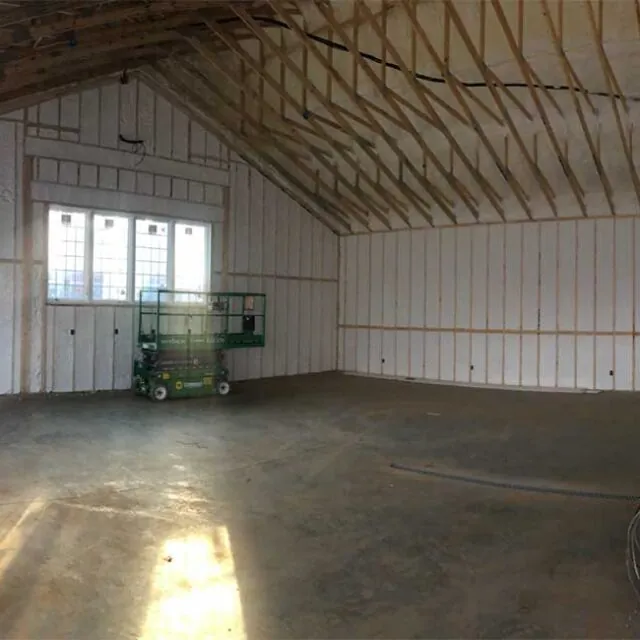 Spray foam insulation installed in the walls and ceiling of a large commercial space.