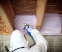 Worker installing insulation in a basement.