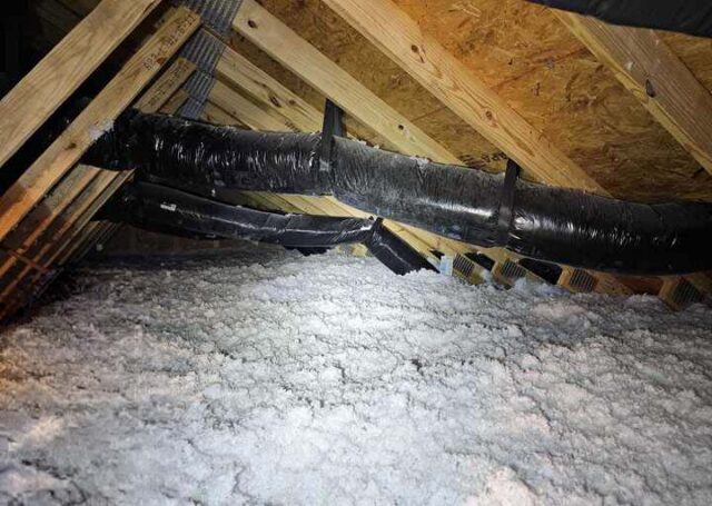 Blown-in insulation covering an attic floor around wrapped ductwork on a Southland Insulators job in Manassas, VA.