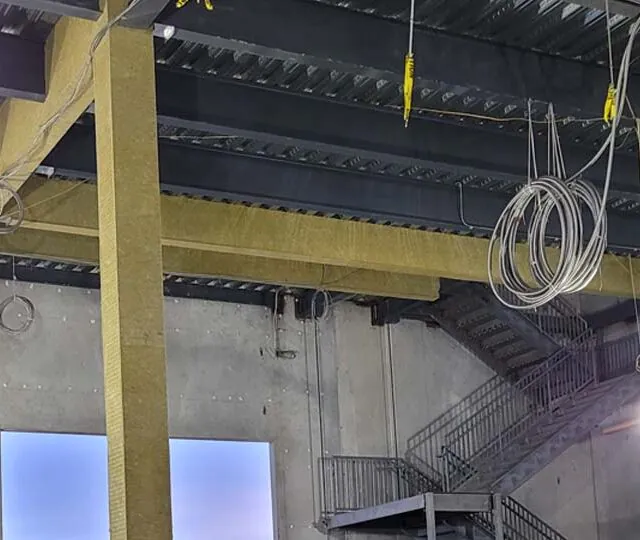 Mineral wool fireproofing on a steel beam in a data center. Mineral wool fireproofing on a steel beam in a data center.