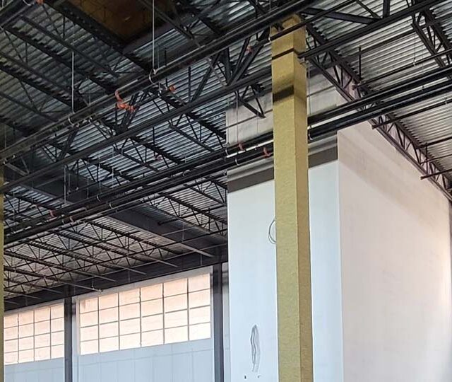 Mineral wool fireproofing on multiple steel columns inside a data center. Mineral wool fireproofing on multiple steel columns inside a data center.