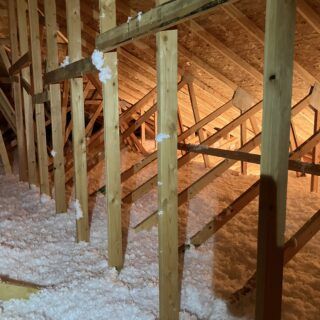 Freshly installed blown in fiberglass insulation in an attic space.