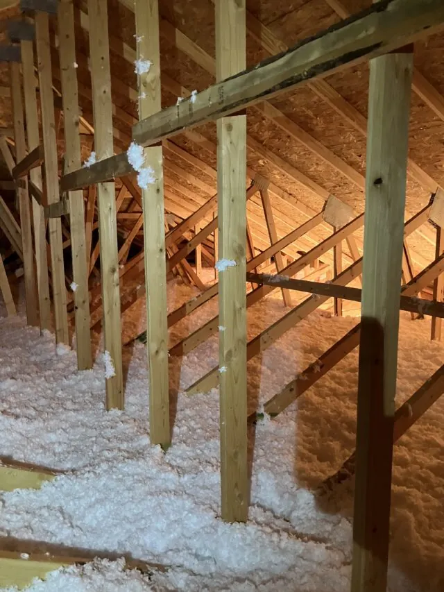Freshly installed blown in fiberglass insulation in an attic space.