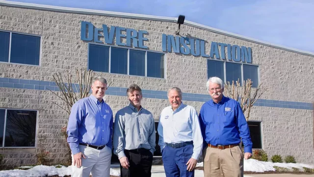 DeVere leadership team standing in front of DeVere's Headquarters building.