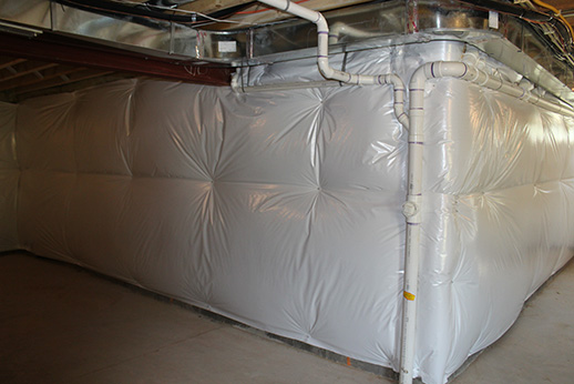 Southland Insulators basement wall insulation with white poly vapor barrier covering full corner walls in a Northern Virginia home.