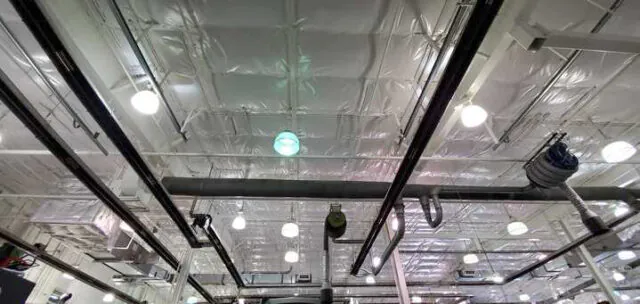 White vinyl PSK faced insulation on ceiling in metal building.
