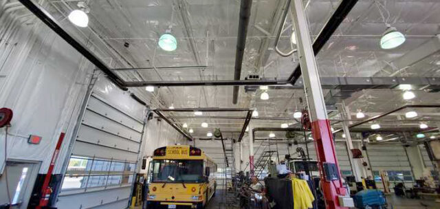 White vinyl PSK faced insulation on ceiling above school bus bay.