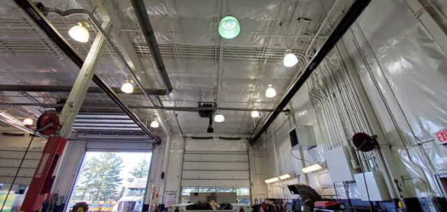 White vinyl PSK faced insulation above overhead door bay in metal building.