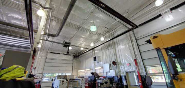 White vinyl PSK faced insulation on wall and ceiling in metal building.