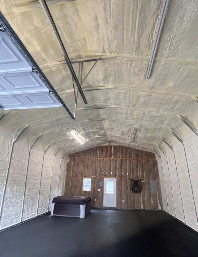 Spray foam and fiberglass batt insulation installed in a metal garage.